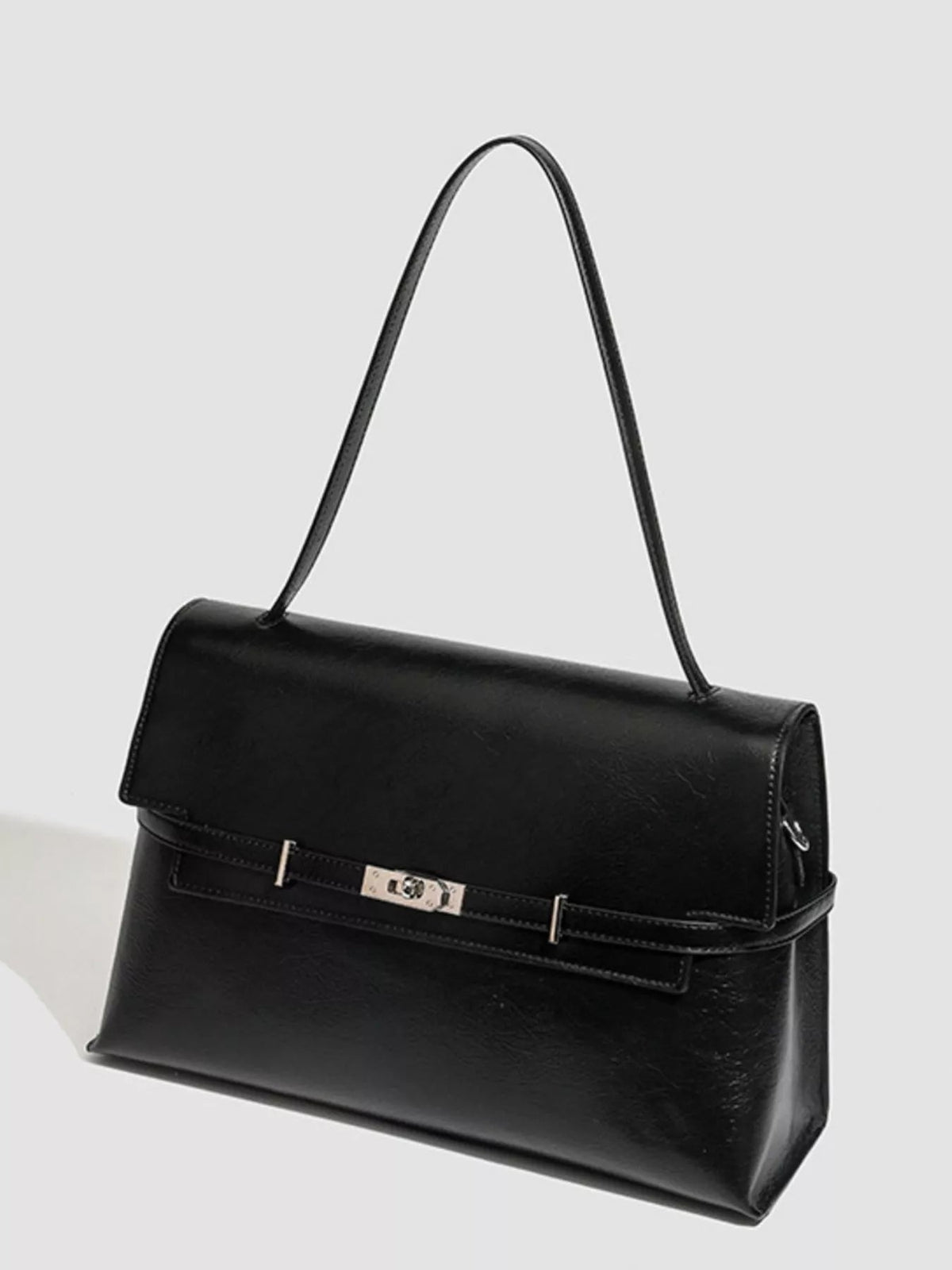 Black medium PU leather shoulder bag with a structured silhouette, folded flap, buckle closure, stitched edges, and a long slim shoulder strap.
