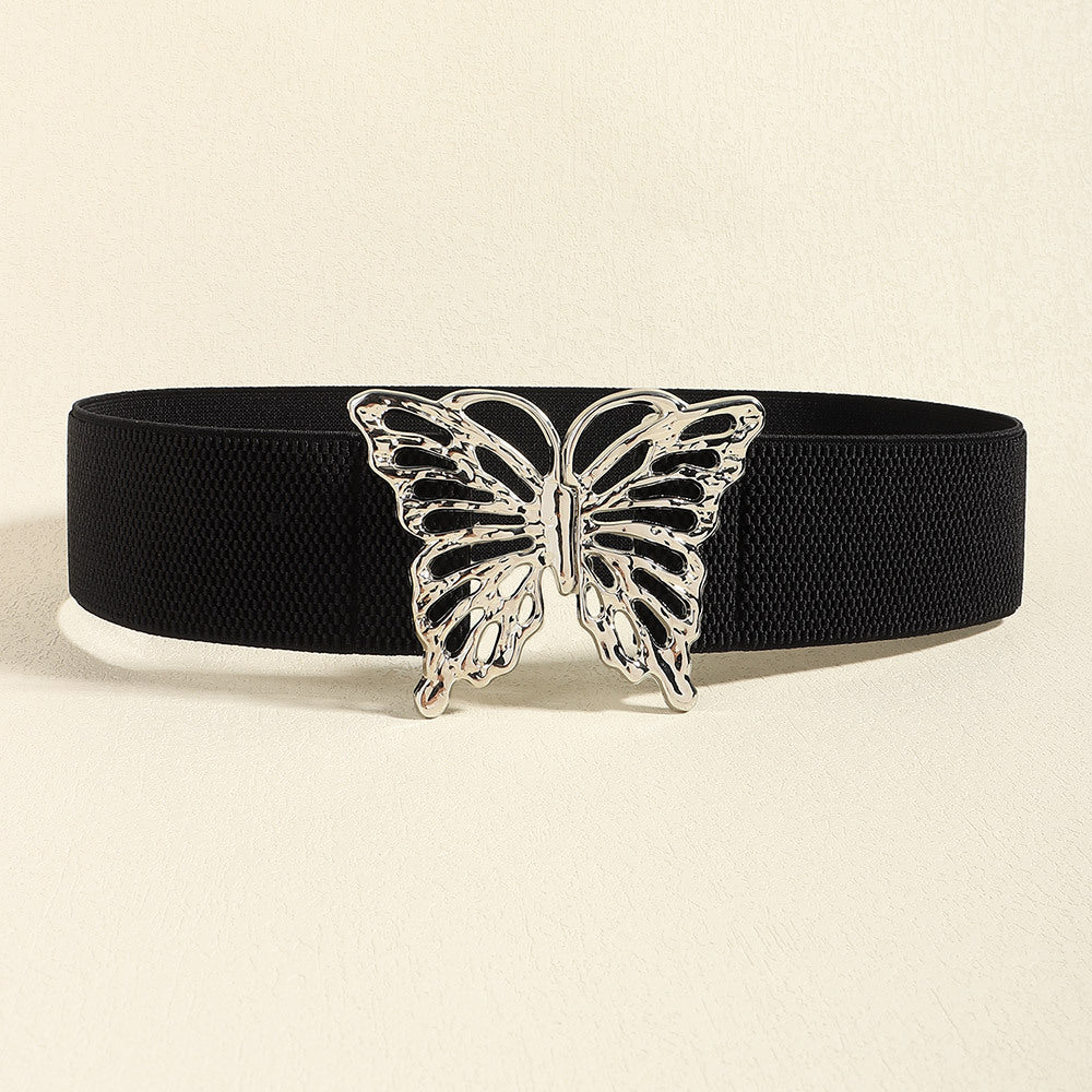 Black elastic belt with a wide textured band and polished silver-tone butterfly alloy buckle, creating a defined waist silhouette with playful feminine style.