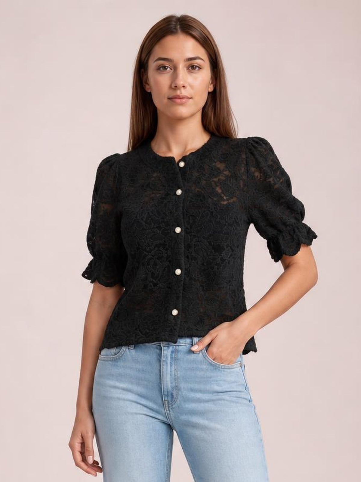 A model wears a black sheer lace button-down shirt with half-length puff sleeves, ruffled cuffs, a round neckline, and a relaxed silhouette.