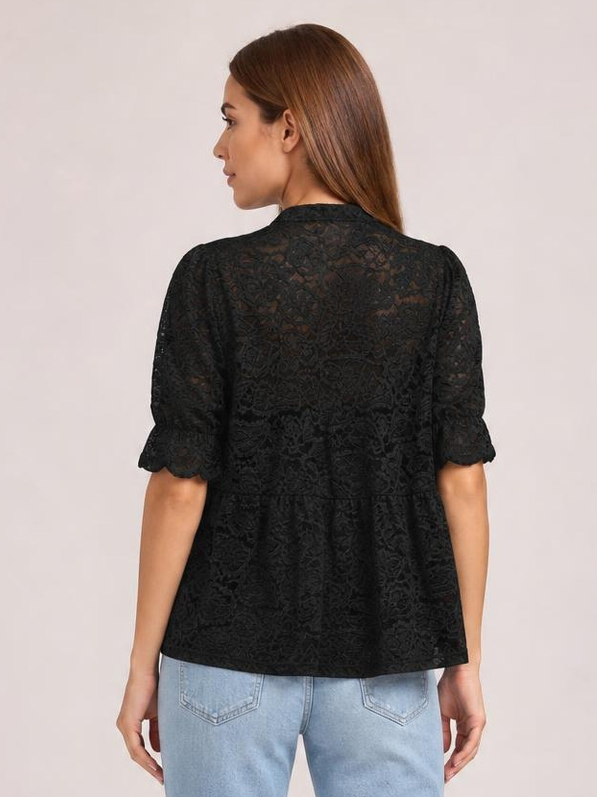 Model shown from behind wearing a black sheer lace shirt with half sleeves, a high neckline, relaxed fit, and gently flared silhouette.