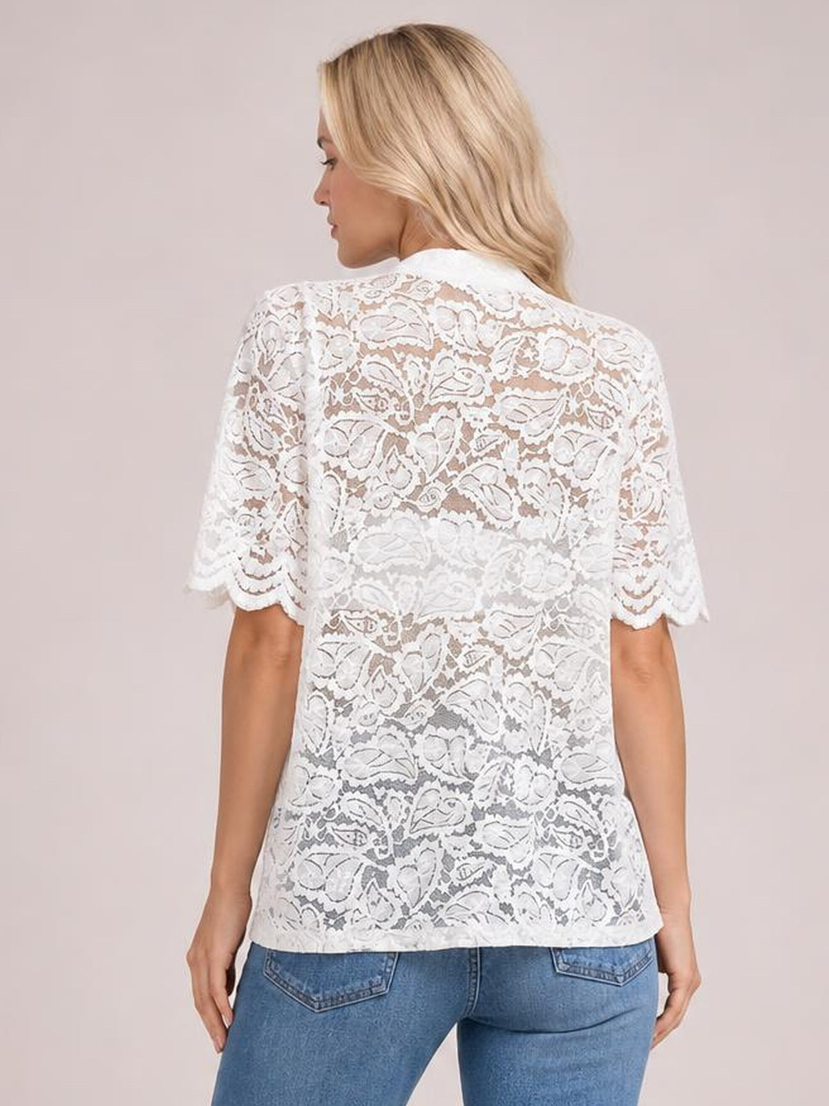 Model shown from behind wearing a white sheer lace button-down shirt with half sleeves, a relaxed straight silhouette, and scalloped sleeve hems.