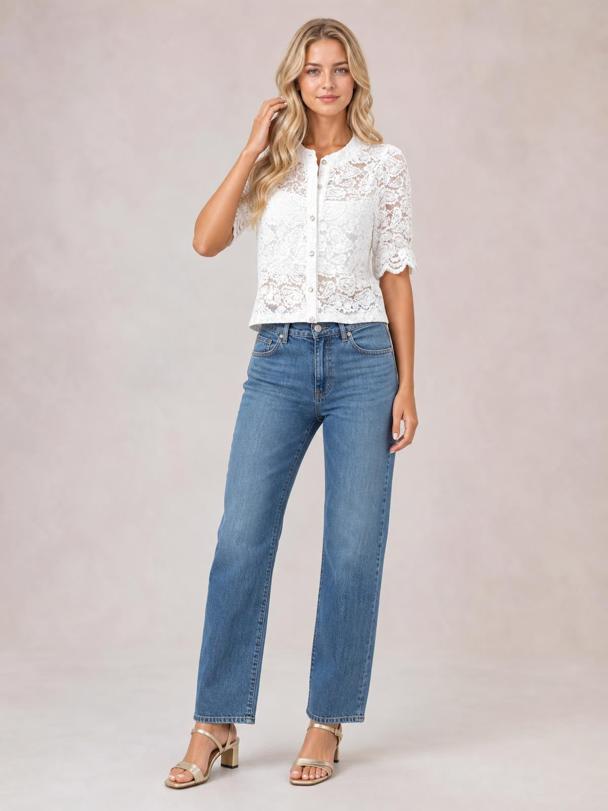 Model touching her hair wears a white sheer lace button-down shirt with half sleeves, a straight cropped silhouette, and delicate scalloped sleeve edges.