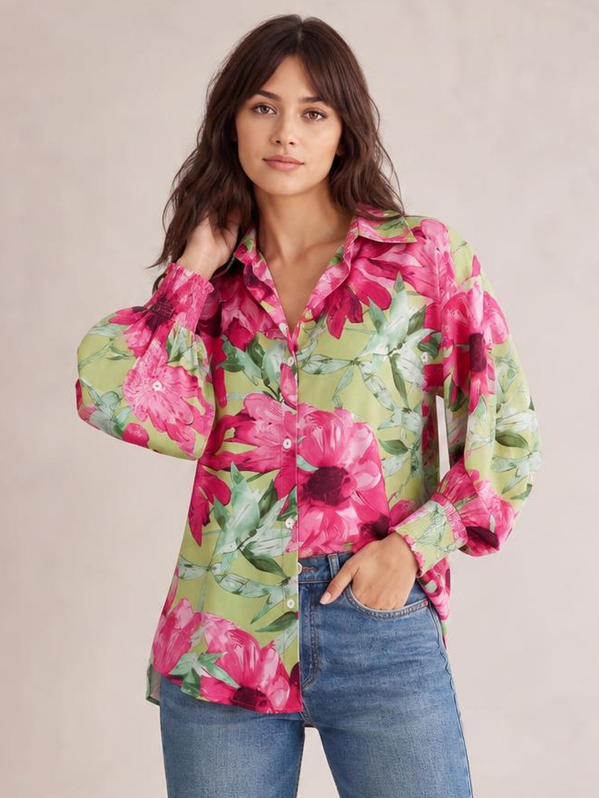 Model poses in a green floral printed long sleeve shirt with a button-down front, collared neckline, relaxed silhouette, and curved hem.