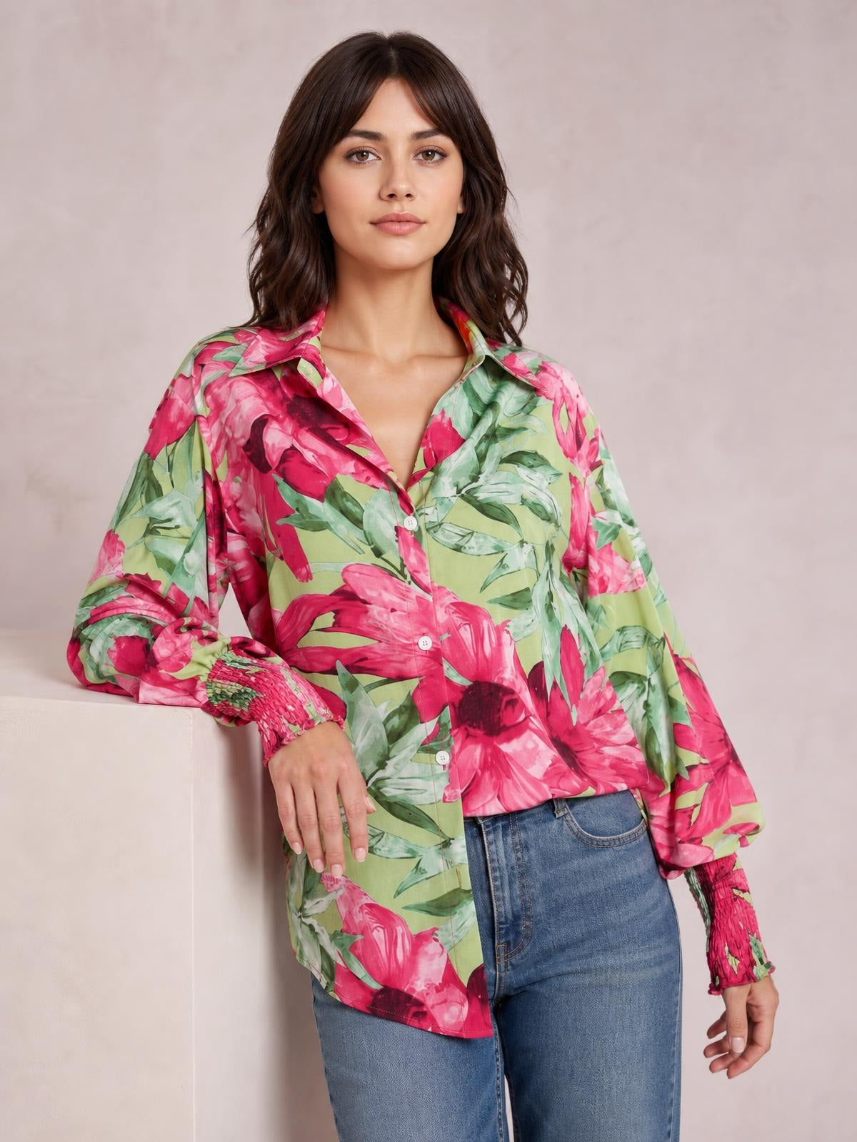 Model wearing a green and pink floral printed button-down shirt with a collared neckline, long sleeves, button front, and relaxed silhouette.