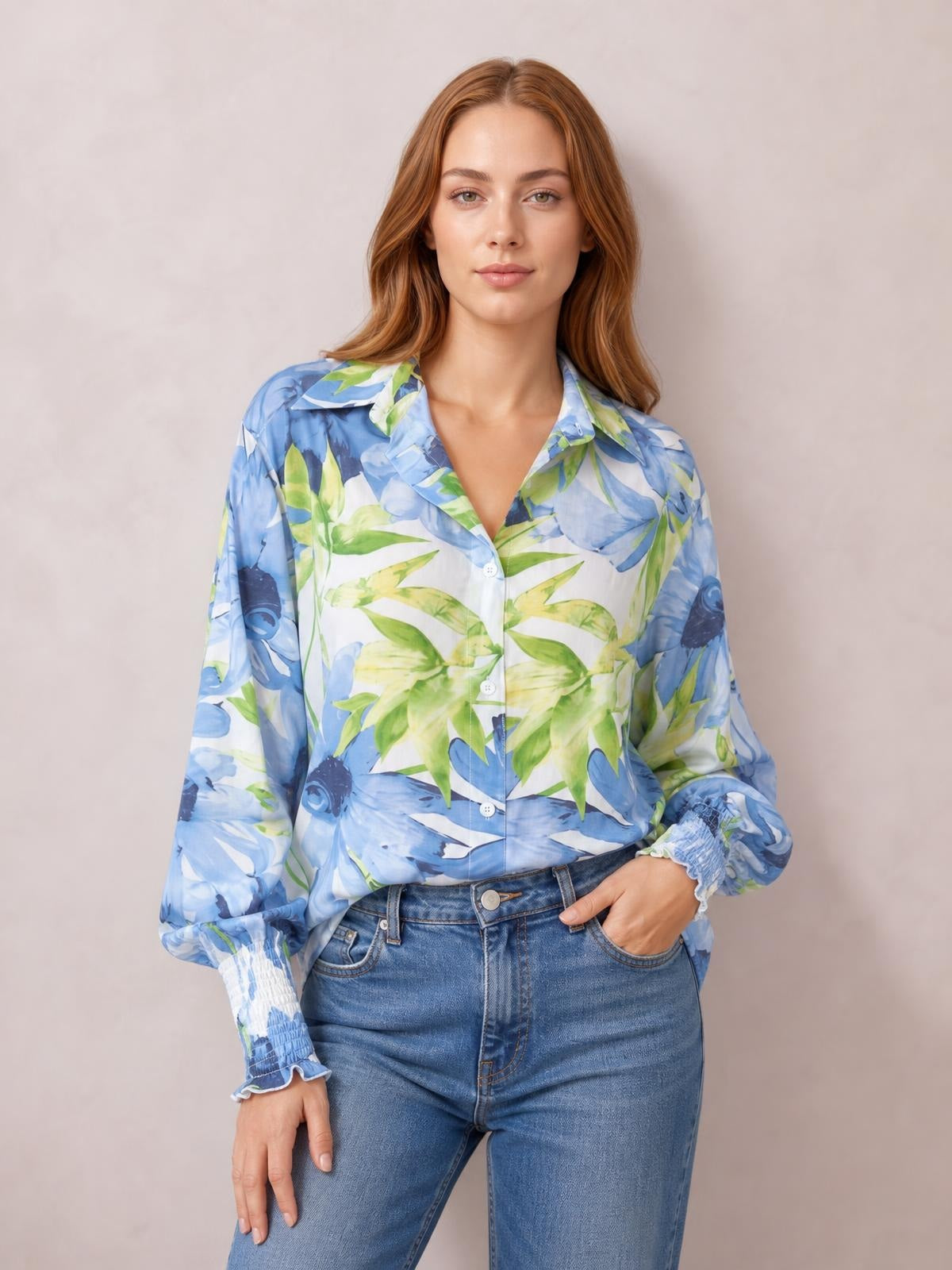 Model wearing a blue and green printed long sleeve button-down shirt with a collared neckline, front buttons, relaxed silhouette, and gathered cuffs.