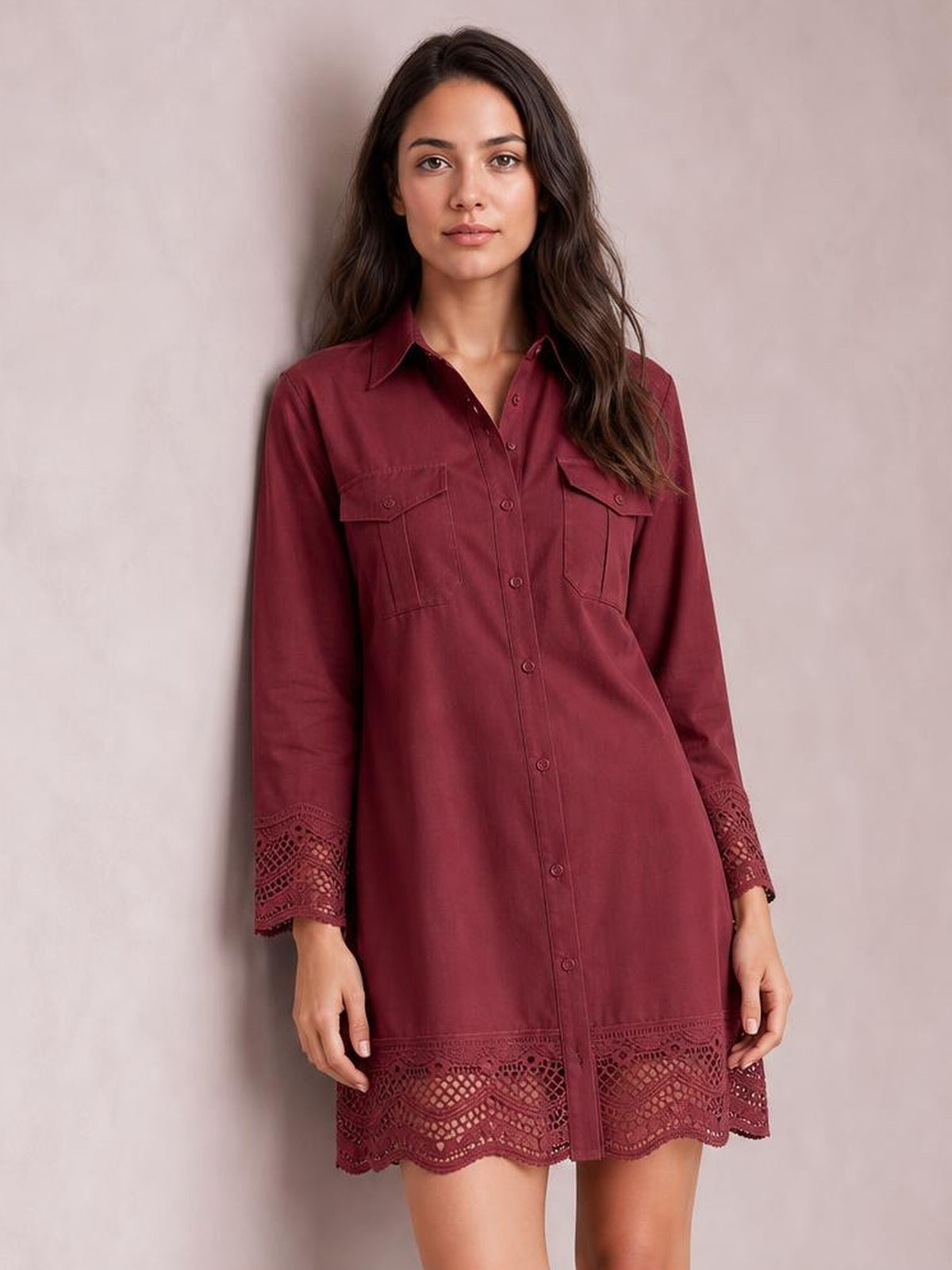 Model wearing a burgundy button-down shirt dress with a relaxed silhouette, flap chest pockets, long sleeves, and lace trim at the cuffs and hem.