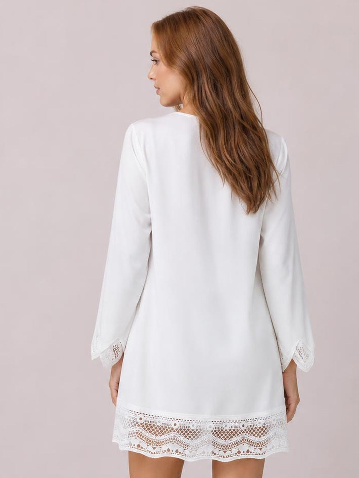 Model shown from the back wearing a white button-down shirt dress with a relaxed silhouette, long sleeves, and lace trim at the cuffs and hem.
