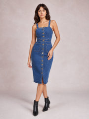 A model poses in a dark blue fitted denim midi dress with wide straps, a softly square neckline, defined seams, button front, and two patch pockets.