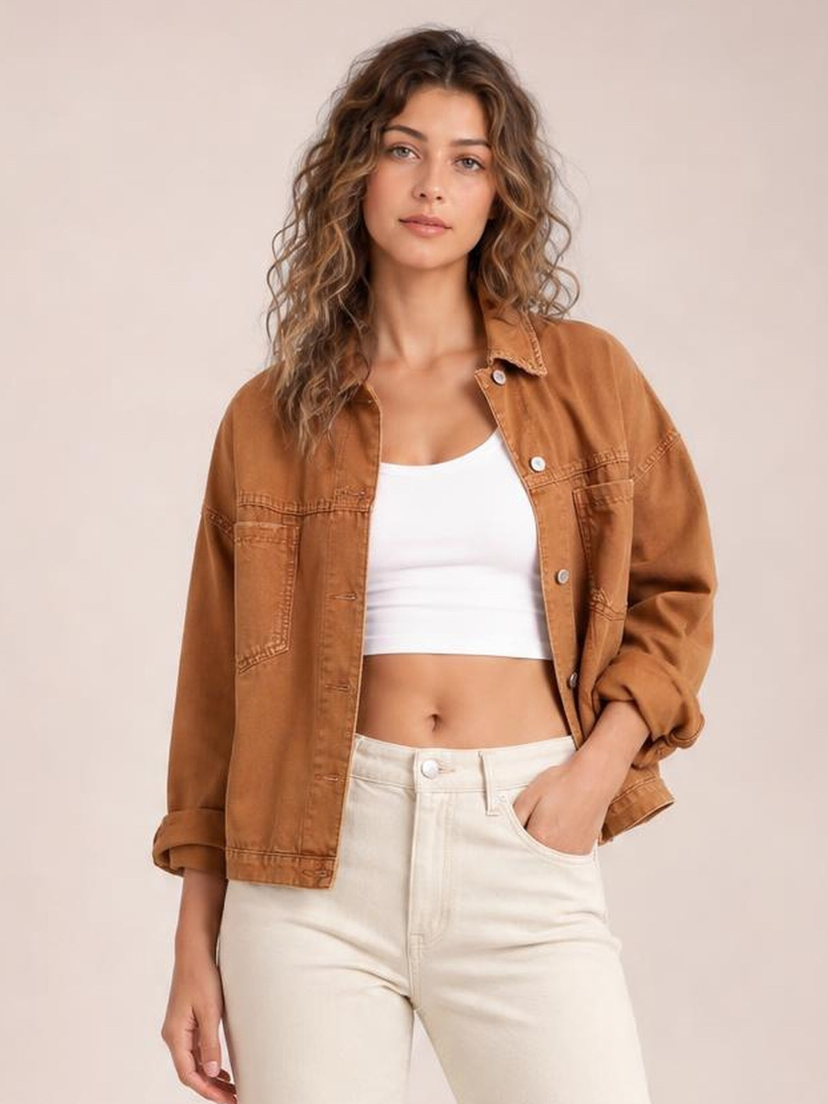 Model wears a rust-brown button-up denim jacket with a drop-shoulder silhouette, pointed collar, chest pockets, long sleeves, and rolled cuffs.