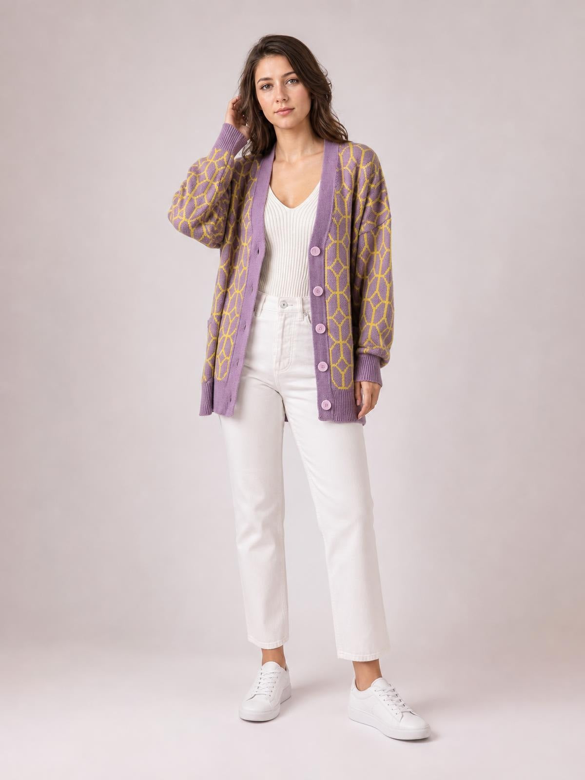 Model poses in a relaxed lavender button-up long sleeve cardigan with yellow geometric pattern, ribbed edges, and a long, easy silhouette.