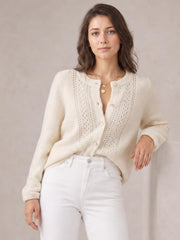 Model wearing an ivory button-up long sleeve cardigan with a round neckline, textured open-knit front panels, ribbed cuffs, and a relaxed silhouette.