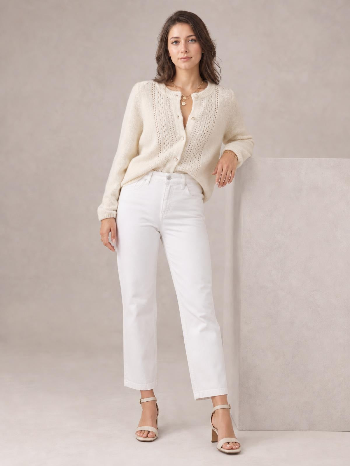 Model wears an ivory button-up long sleeve cardigan with a rounded neckline, textured open-knit front panels, and a relaxed silhouette.