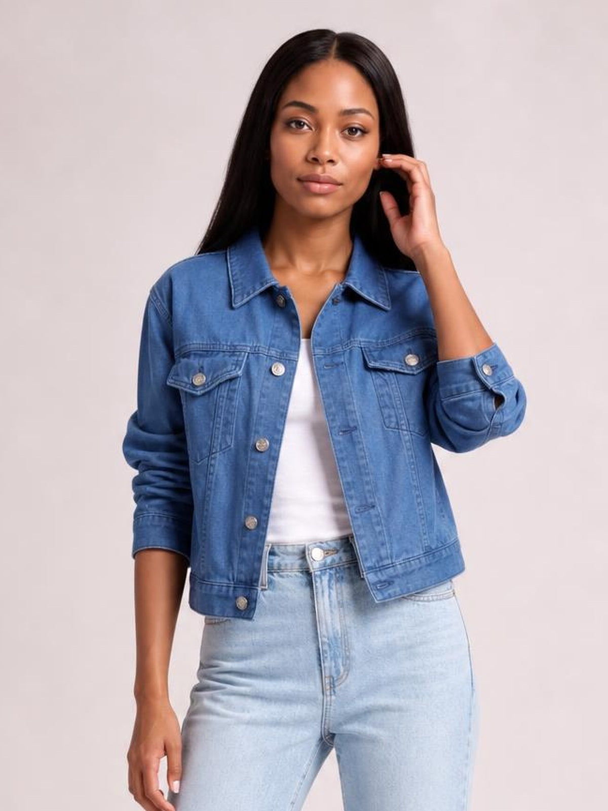 Model wears a blue button-up long sleeve denim jacket with a collared, structured silhouette, chest flap pockets, and rolled cuffs.