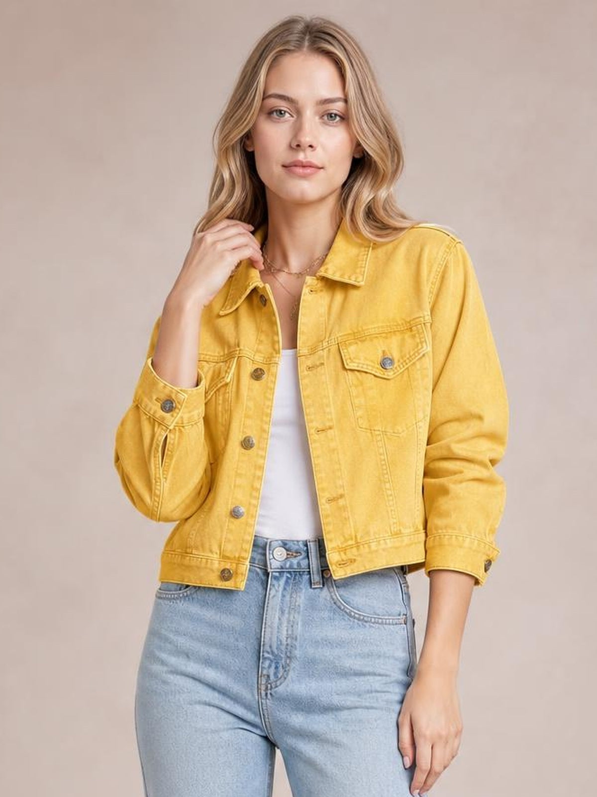 A model poses in a yellow button-up long sleeve denim jacket with a collared neckline, chest pockets, visible stitching, and a relaxed cropped silhouette.