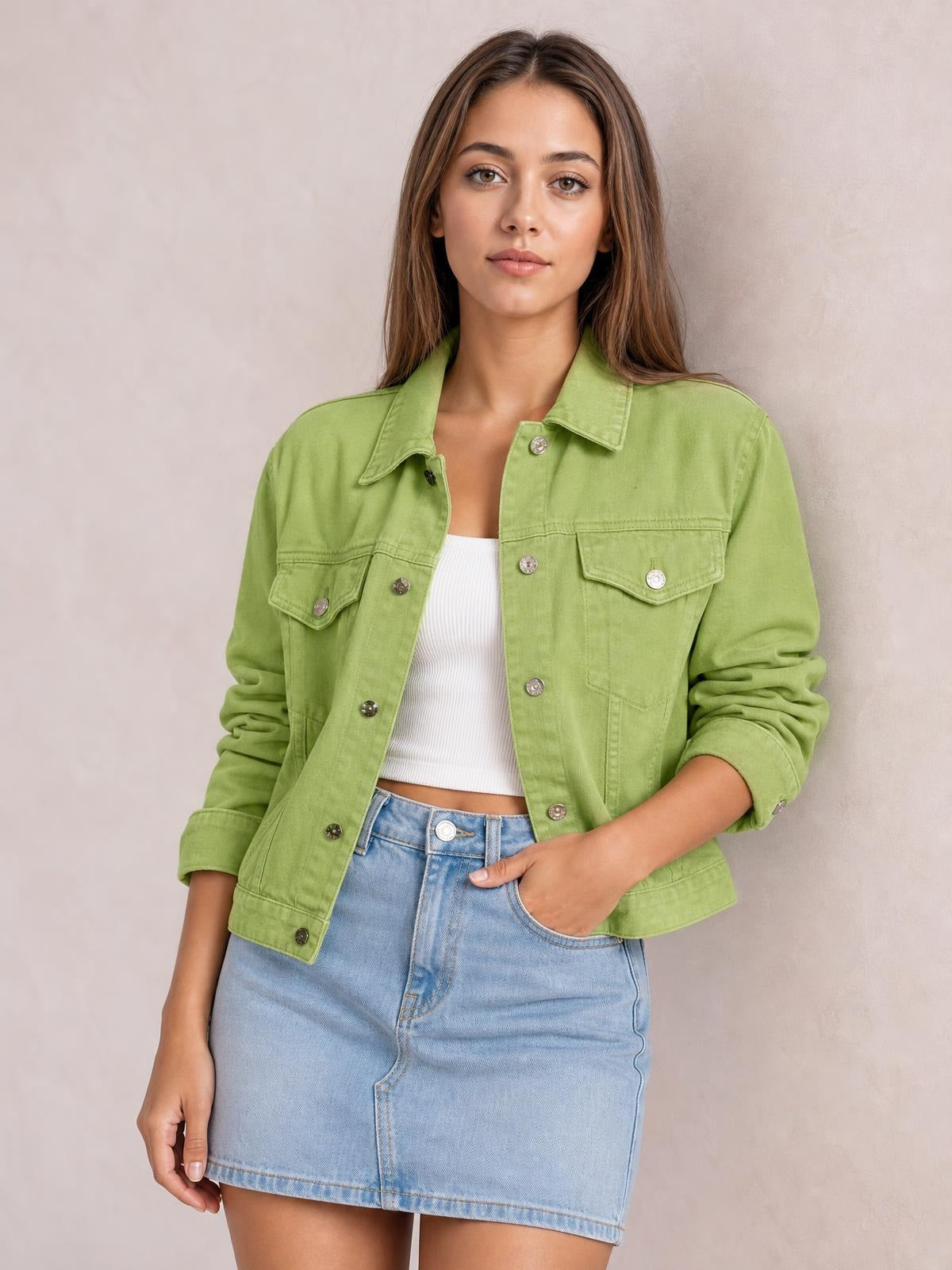 Model wearing a light green button-up long sleeve denim jacket with a relaxed silhouette, pointed collar, chest flap pockets, and rolled cuffs.