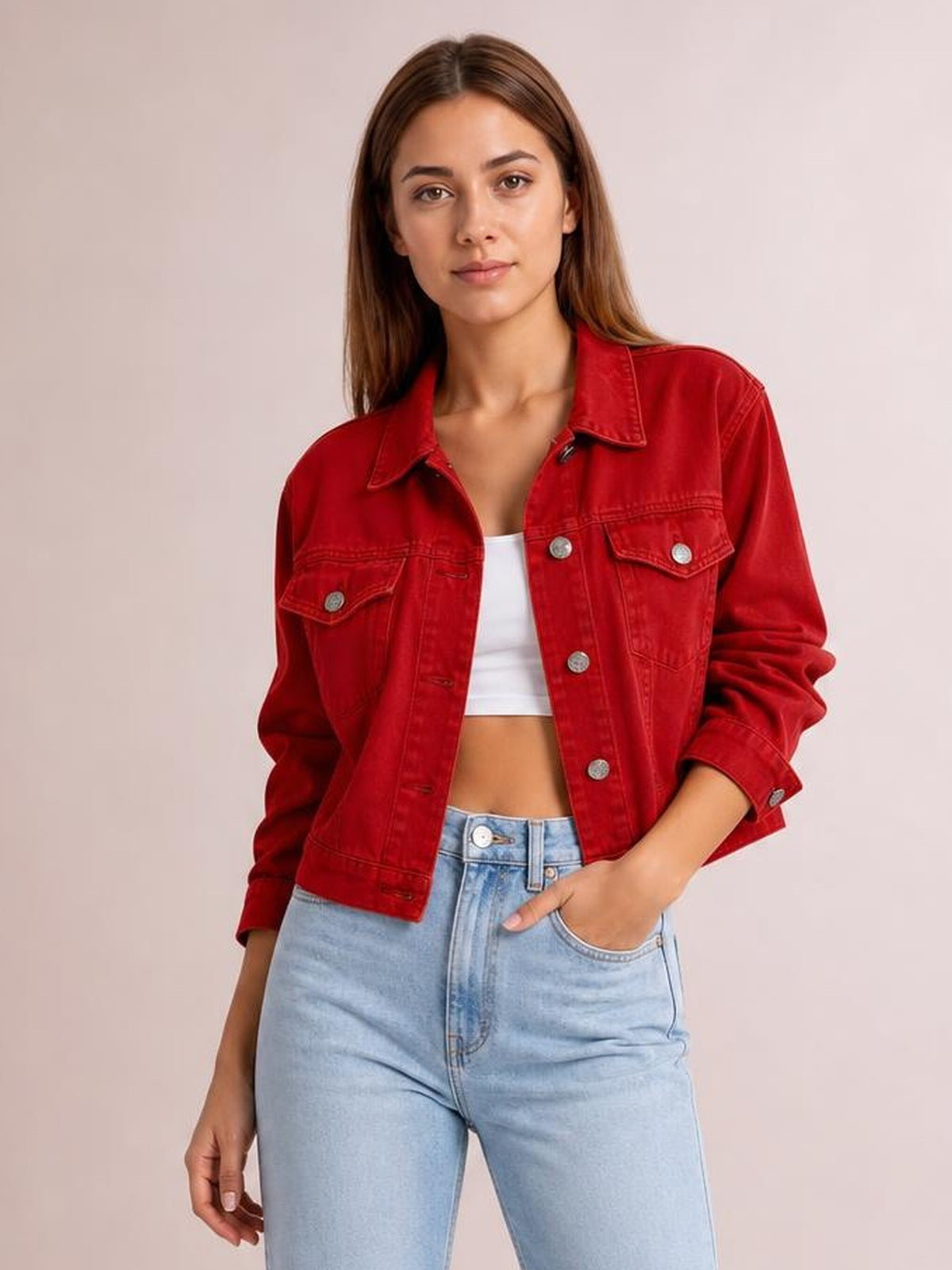 A model poses in a red button-up long sleeve denim jacket with a collared neckline, flap chest pockets, and a cropped silhouette.
