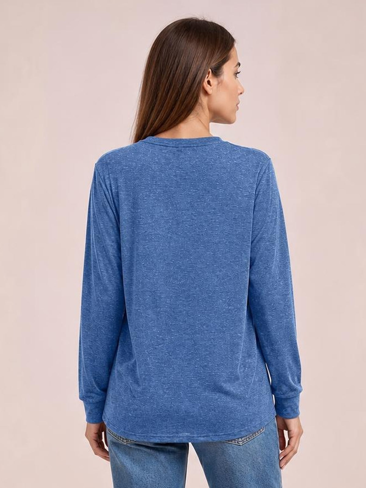 Model shown from the back in a blue long sleeve top with a relaxed silhouette, crew neckline, straight hem, and fitted cuffs.