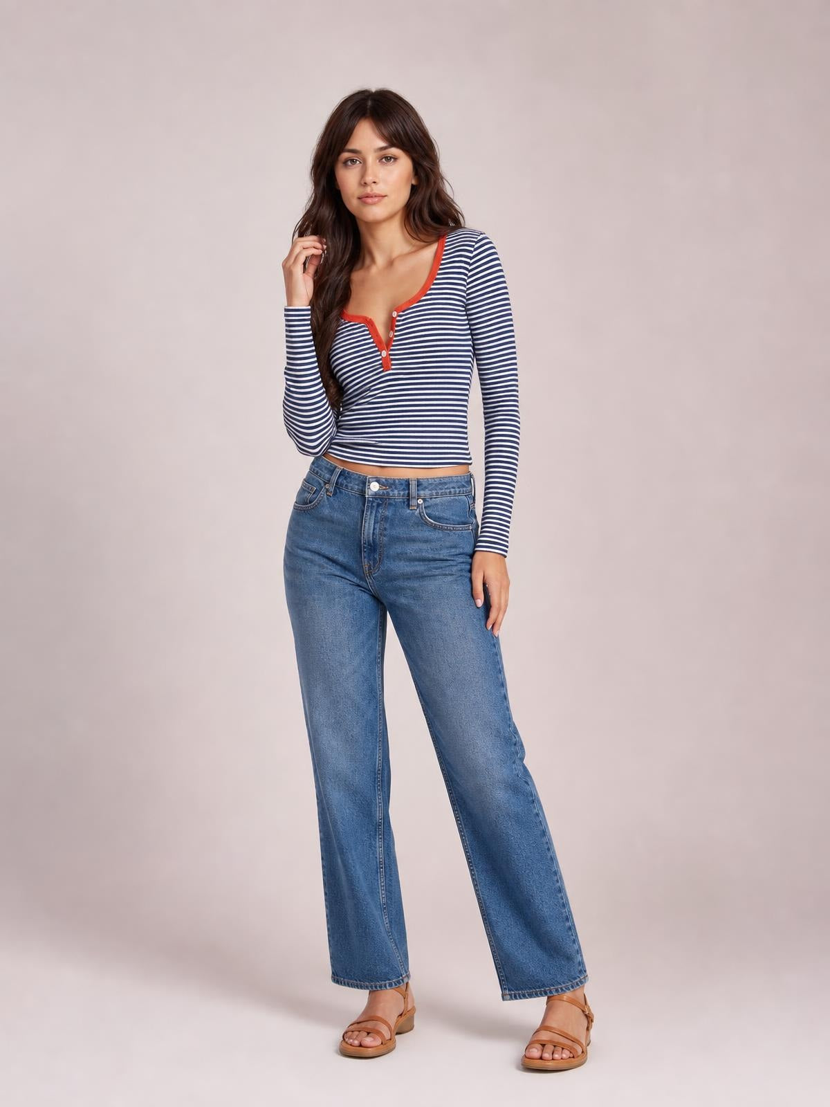 Model poses in a navy and white striped long sleeve T-shirt with a red-trimmed button placket and fitted silhouette.