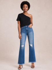 A model poses with one hand in the pocket, wearing blue high-rise distressed bootcut jeans with a classic five-pocket design and raw frayed hems.