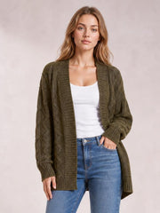 Model wearing an olive-brown cable-knit open-front cardigan with long sleeves, ribbed trim, and a relaxed long silhouette over a white top and jeans.