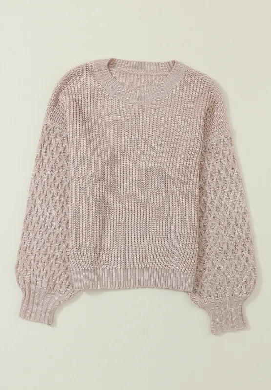 Pale blush pink cable-knit sweater with a round neck, dropped shoulders, textured sleeves, and a relaxed straight silhouette with ribbed cuffs and hem.