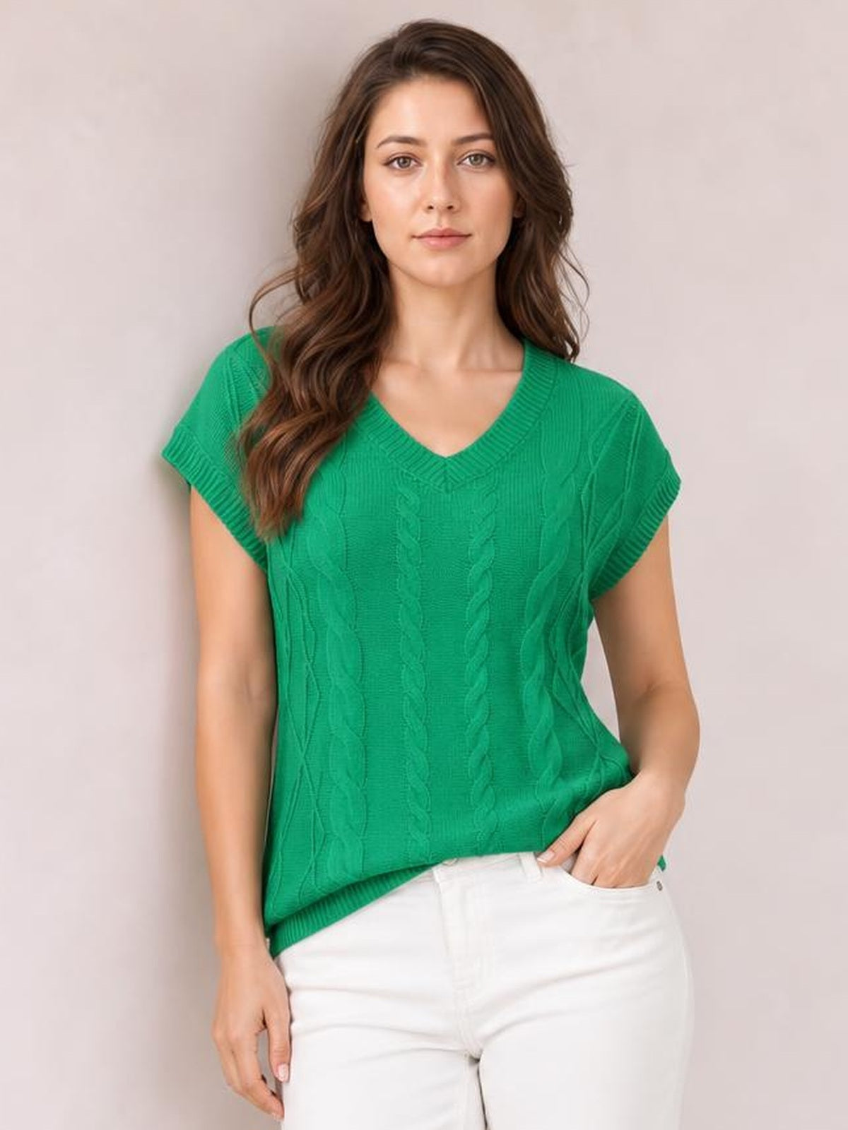 Model poses with one hand in her pocket while wearing a bright green cable-knit V-neck short-sleeve top with ribbed trim and a relaxed silhouette.