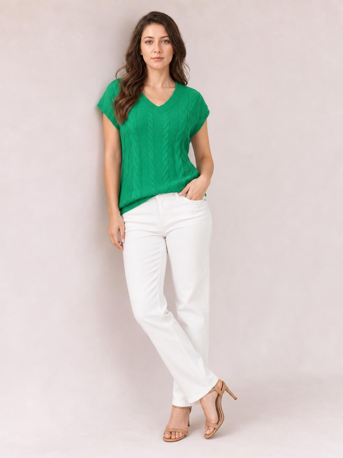 Model poses in a bright green cable-knit V-neck short sleeve knit top with ribbed trim, a gently fitted silhouette, and a slightly curved hem.
