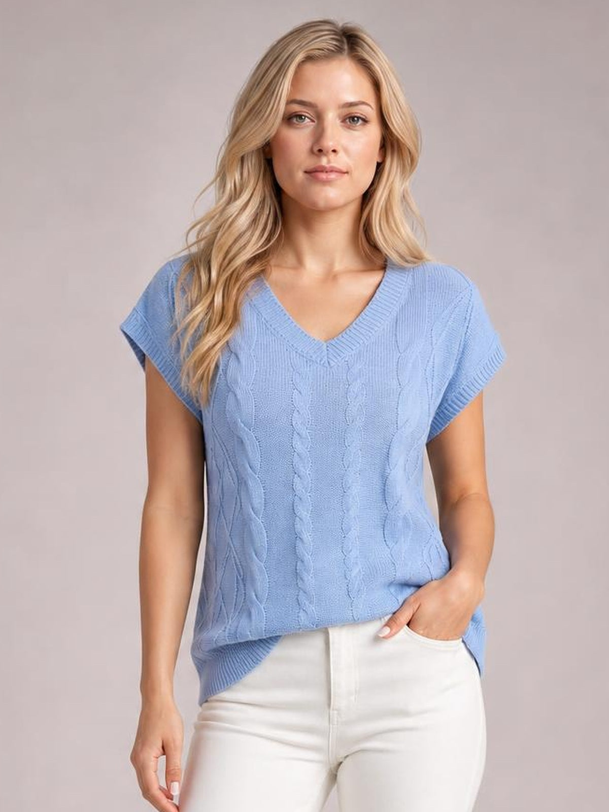 Model wears a light blue cable-knit V-neck short sleeve top with ribbed trim and a relaxed, straight silhouette, paired with white pants.