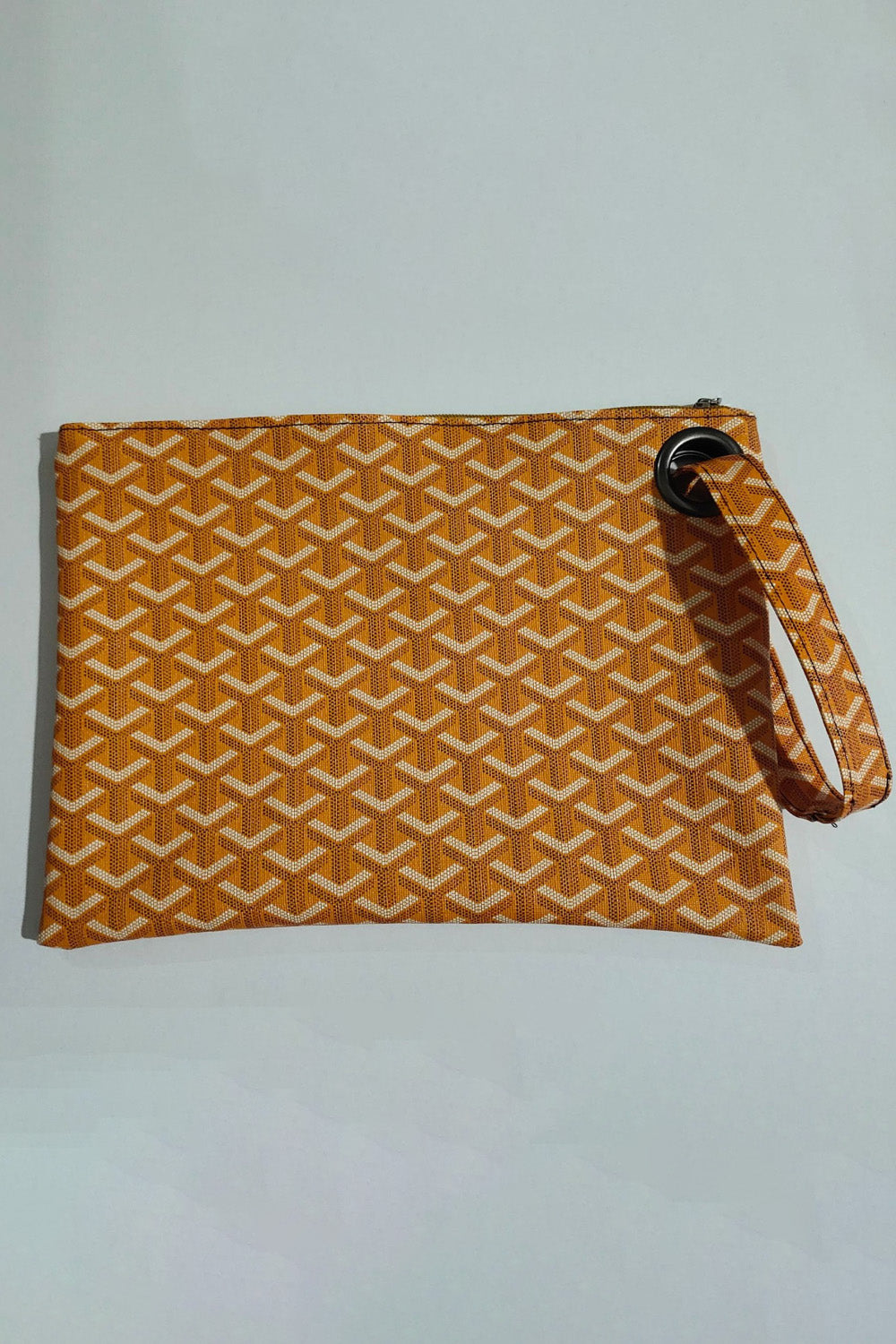 A medium orange PU leather wristlet with a clean rectangular silhouette, white geometric pattern, top zipper, and matching wrist strap attached through a black ring.