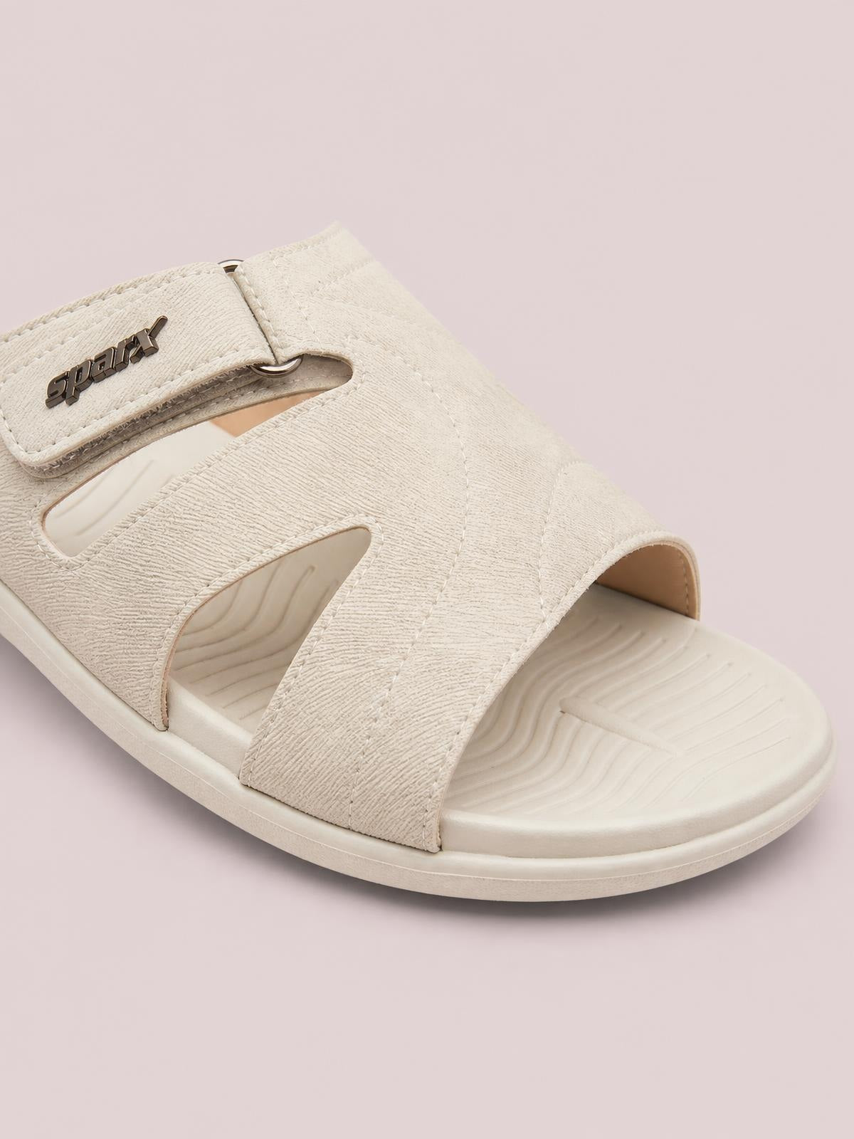 Cream PU leather cut-out platform slides feature wide textured straps, a metal logo accent, open sides, and a cushioned EVA sole.