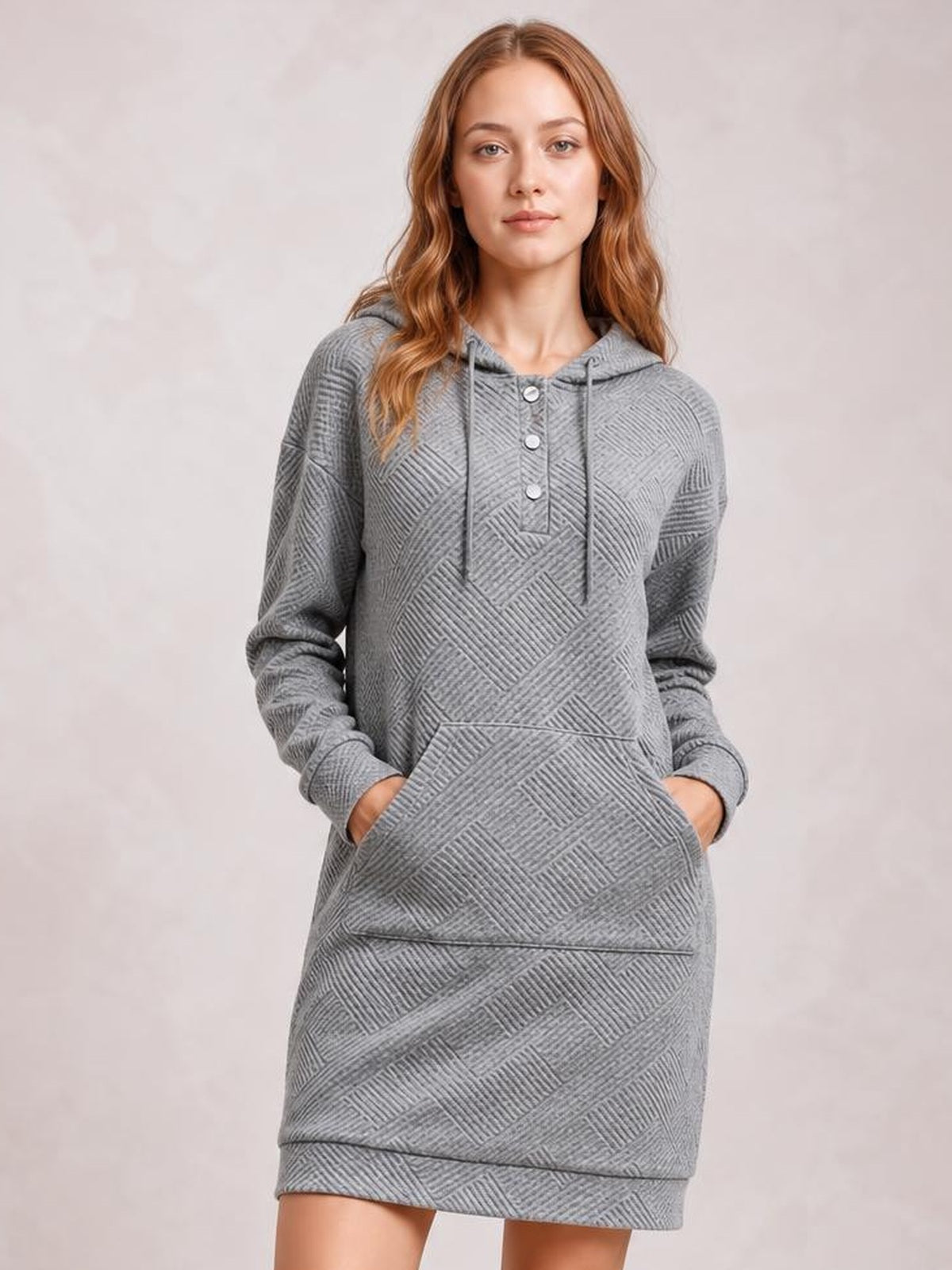 Model wears a gray textured hooded sweatshirt dress with drawstrings, button placket, long sleeves, kangaroo pocket, and relaxed straight silhouette.