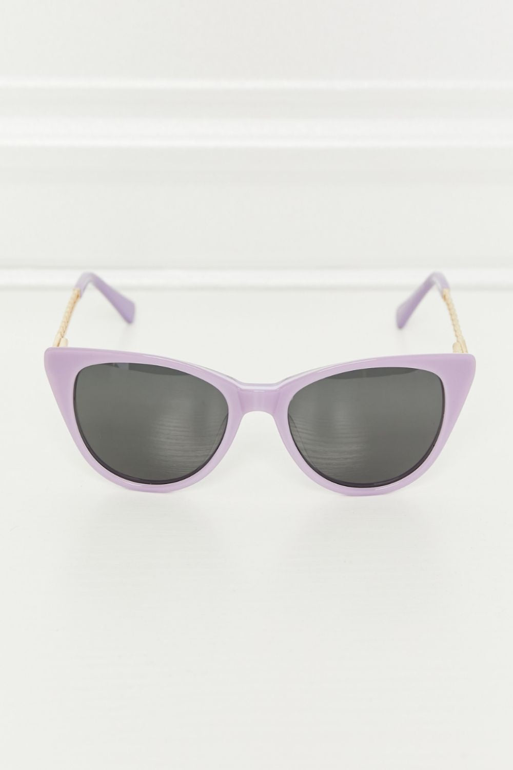 Lavender acetate cat-eye sunglasses feature dark TAC polarized lenses and softly upswept frames with gold-tone metal and acetate temples.