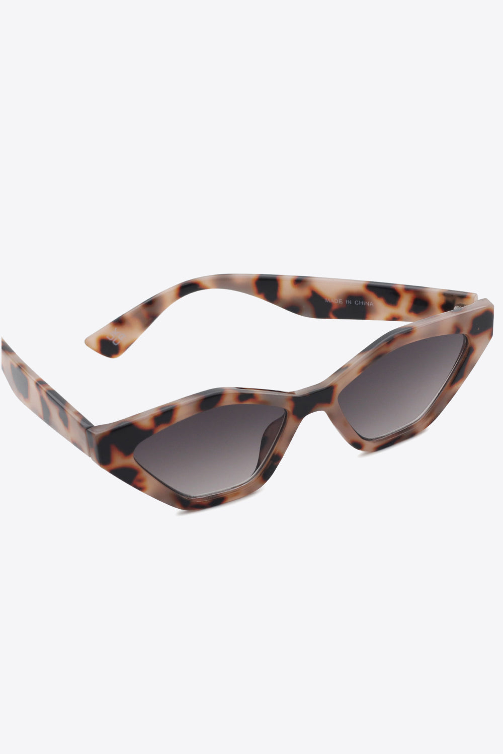 Tortoiseshell polycarbonate cat-eye sunglasses feature angular frames, lifted outer corners, and dark lenses in a sleek, structured silhouette.