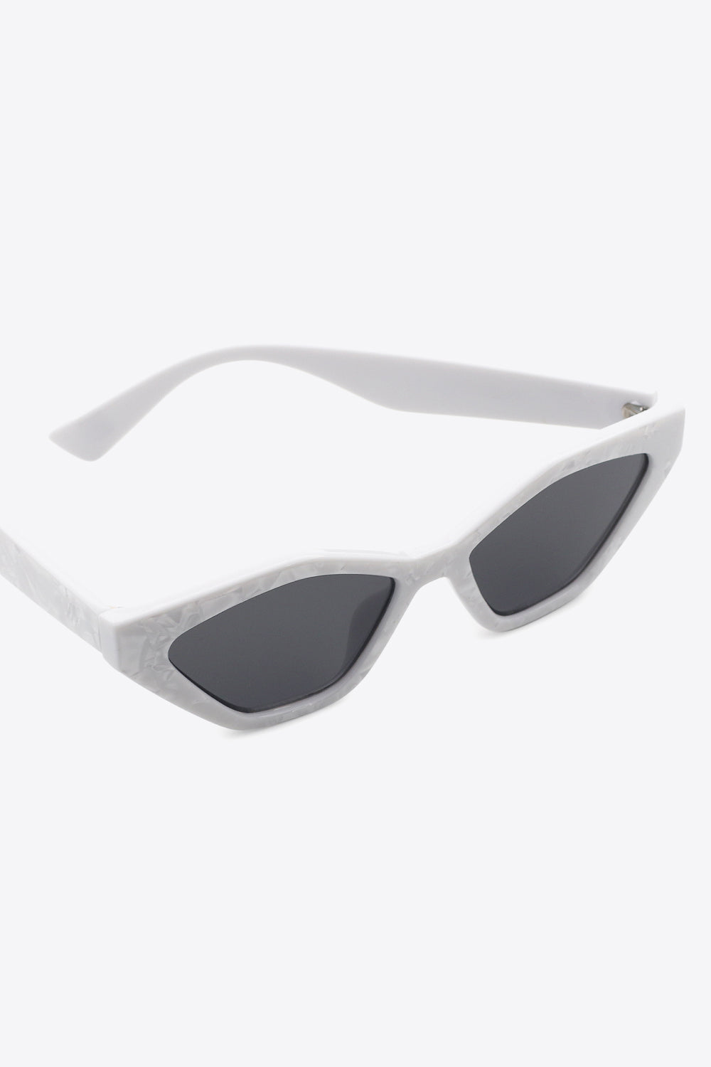 White polycarbonate cat-eye sunglasses feature dark lenses, angular frames with lifted outer corners, and sleek curved temples in a three-quarter view.