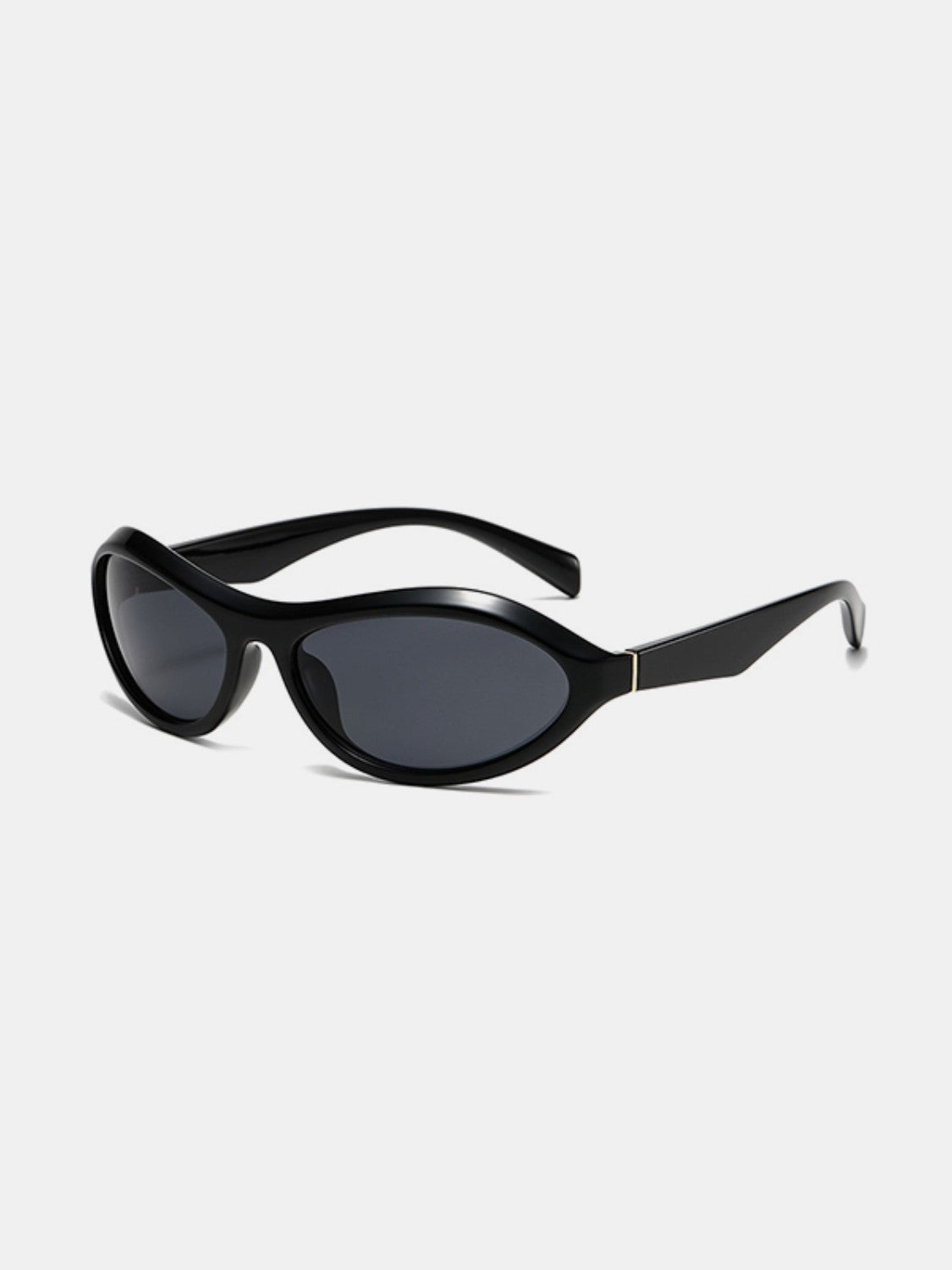 Black polycarbonate cat-eye sunglasses shown at a three-quarter angle, featuring dark lenses, a softly swept silhouette, sculpted frames, and tapered temples.