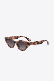 Tortoiseshell cat-eye sunglasses feature angular lenses, lifted outer corners, dark tinted lenses, and sculpted polycarbonate frames with curved temples.