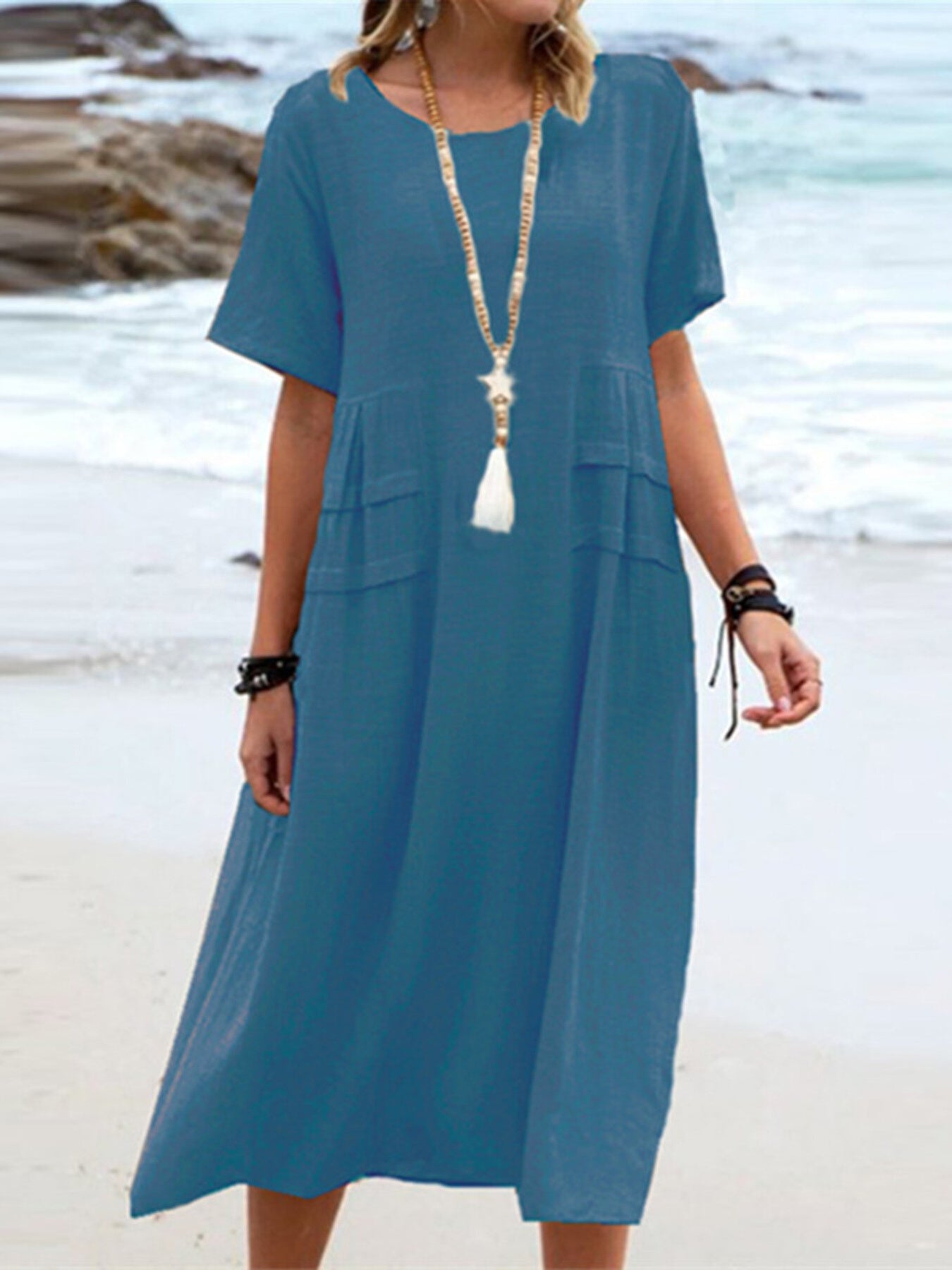 Plus size loose midi dress with short sleeves and pockets shown in cream and black by the beach