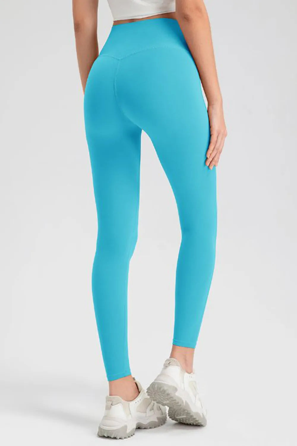Model shown from the back wearing bright turquoise high-waist skinny active pants with a sleek, full-length fitted silhouette and visible center-back seam.