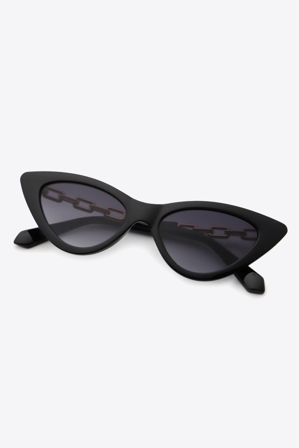 Black cat-eye sunglasses feature a sleek upswept silhouette, dark lenses, and distinctive chain detailing along the temples.