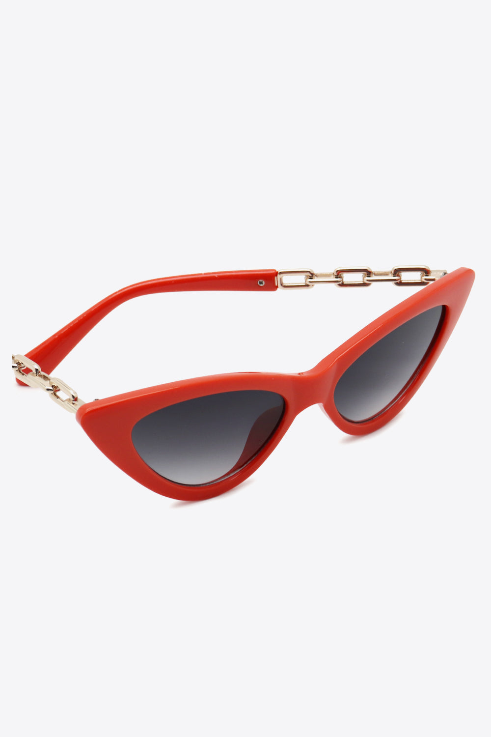 Bright red cat-eye sunglasses feature a sleek upswept silhouette, dark gradient lenses, and polished chain detailing along the temples.