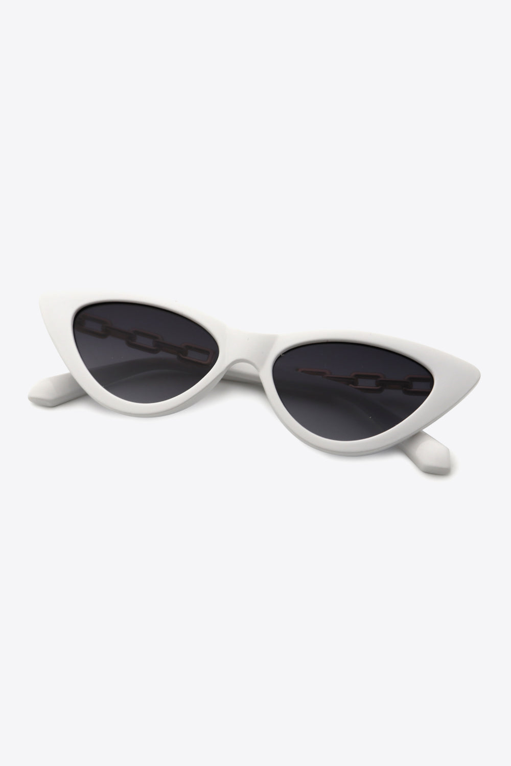 White cat-eye sunglasses feature a sleek upswept silhouette, dark lenses, and distinctive chain detailing along the temples.