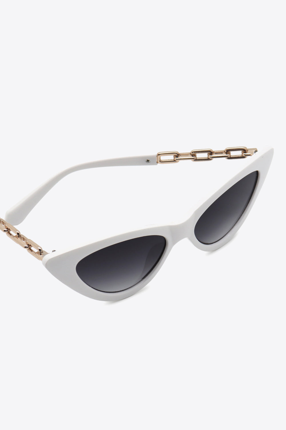 White cat-eye sunglasses feature dark lenses, an upswept silhouette, and distinctive gold chain detailing along the temples.