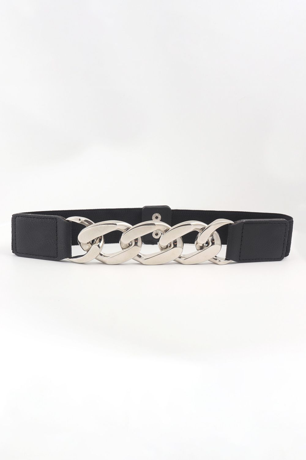 A black elastic waist belt features structured PU end sections and a bold polished silver linked-chain centerpiece for a sculptural statement accent.