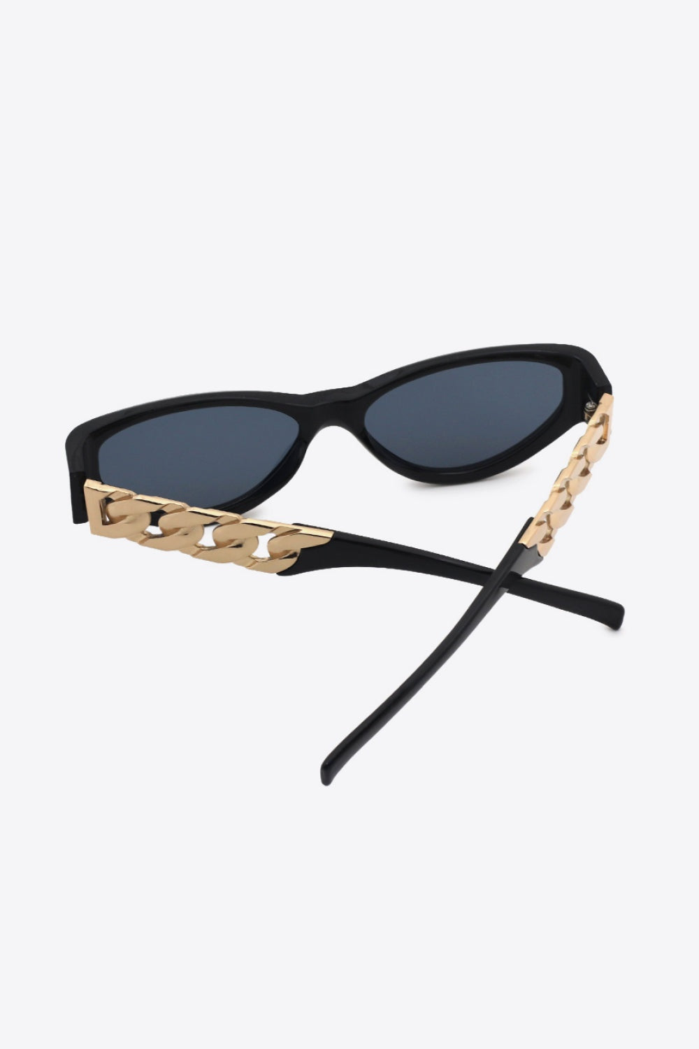 Black cat-eye sunglasses with dark lenses, sleek upswept frames, and distinctive gold chain-detail temples for a bold vintage-inspired look.