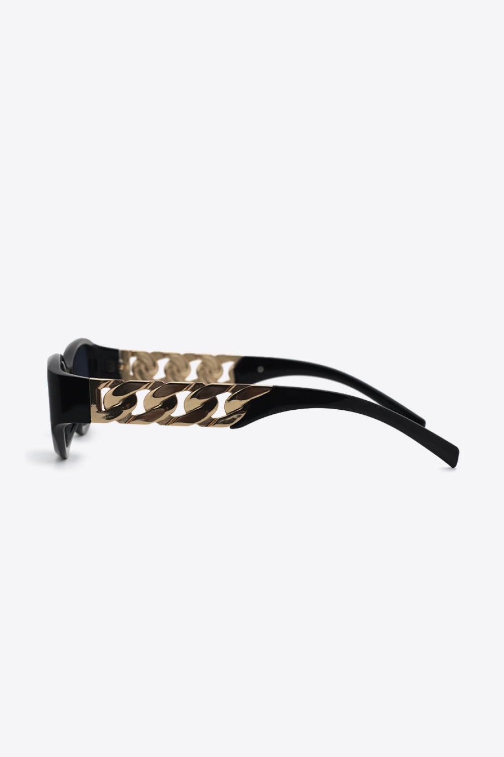 Black cat-eye sunglasses feature dark lenses, a sleek upswept frame, and polished gold chain detail along the temples with curved arms.