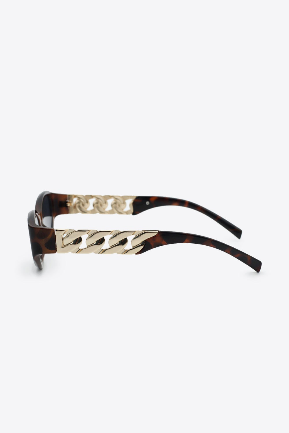Tortoiseshell cat-eye sunglasses feature upswept frames, dark lenses, and polished gold chain detail along the temples.