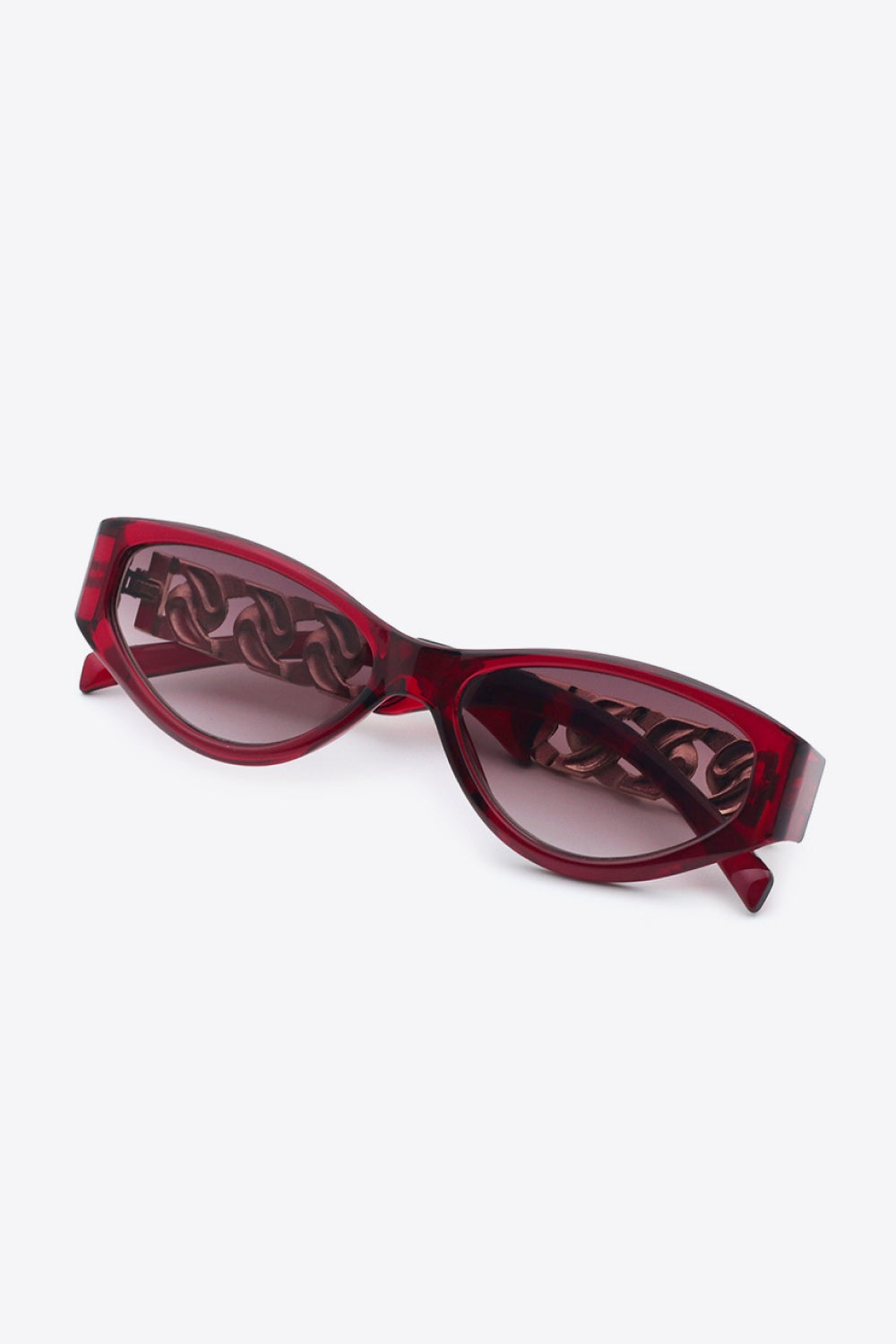 Burgundy cat-eye sunglasses feature an upswept silhouette, tinted acetate lenses, and distinctive chain-inspired temple details visible through the frames.