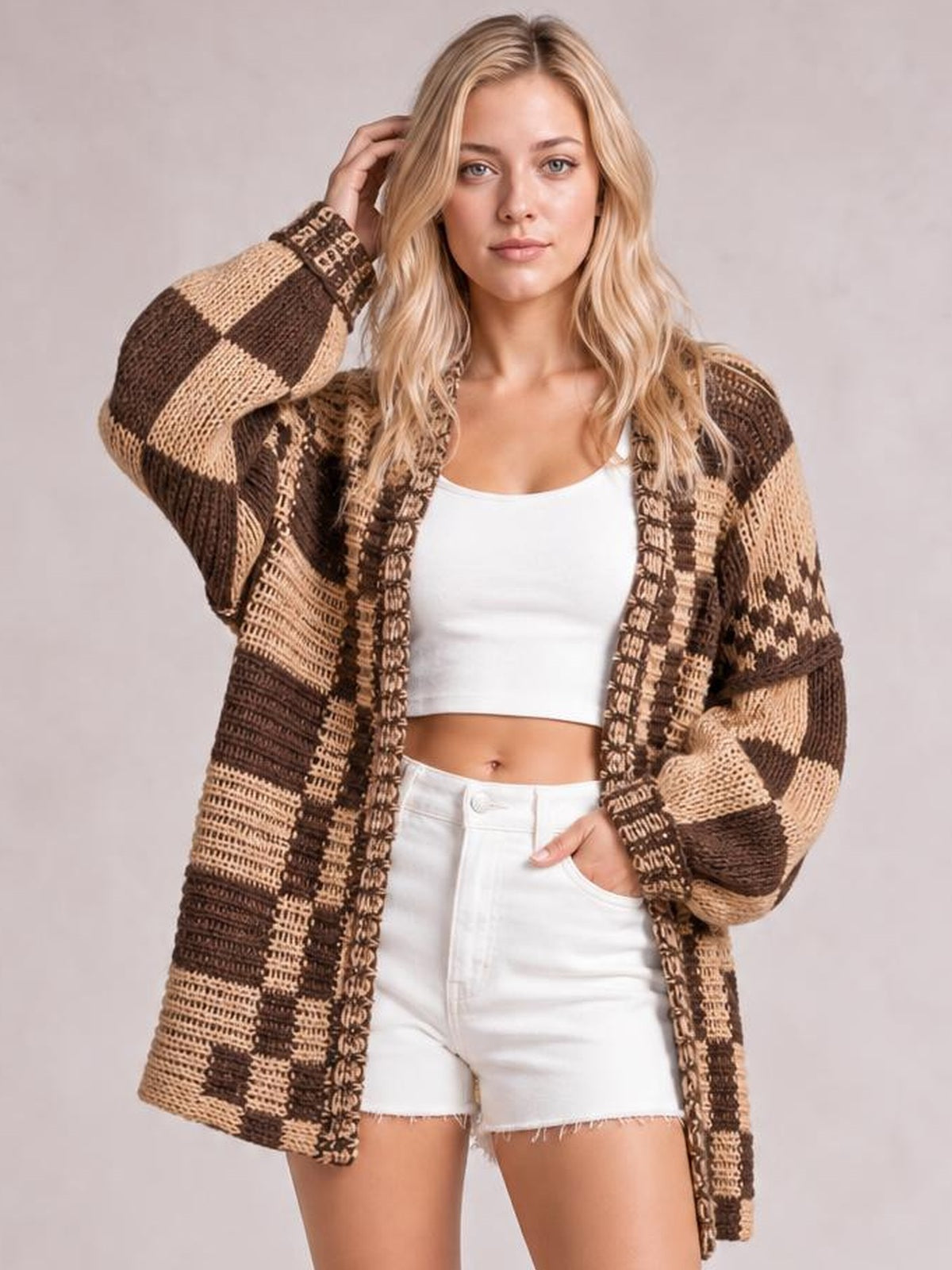 Model wearing a brown and tan checkered open-front long-sleeve cardigan with a relaxed oversized silhouette and textured knit construction.