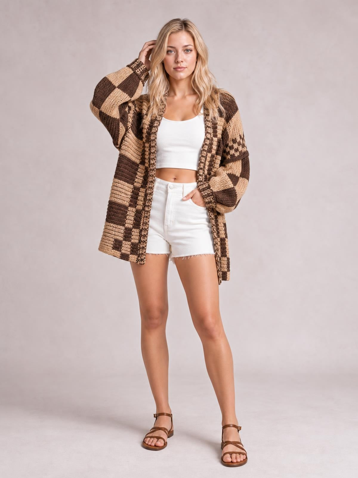 Model wearing a brown and beige checkered open-front long-sleeve cardigan with a relaxed long silhouette, textured knit construction, and oversized sleeves.