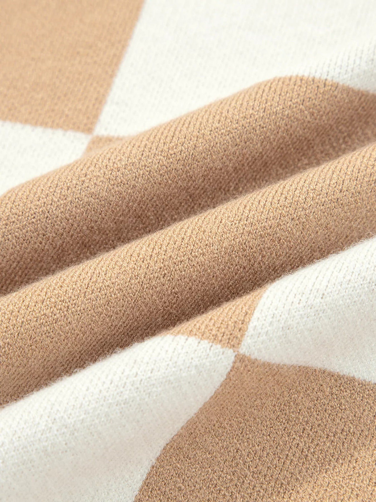 Close-up of the checkered pattern sweater showing tan and cream knit fabric with a soft, finely textured construction.